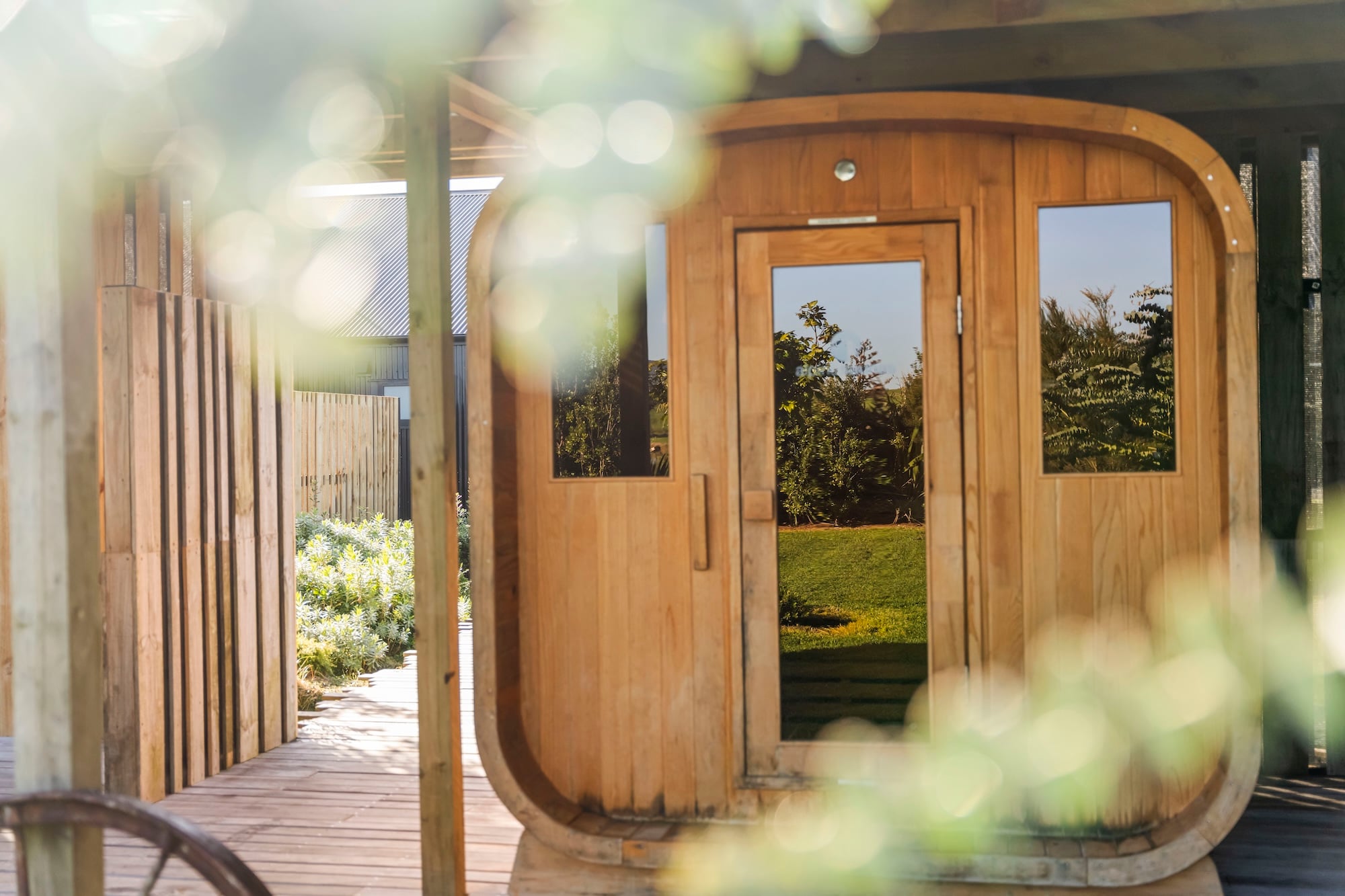 The cedar barrel sauna on the deck at The SHrED, surrounded by planting